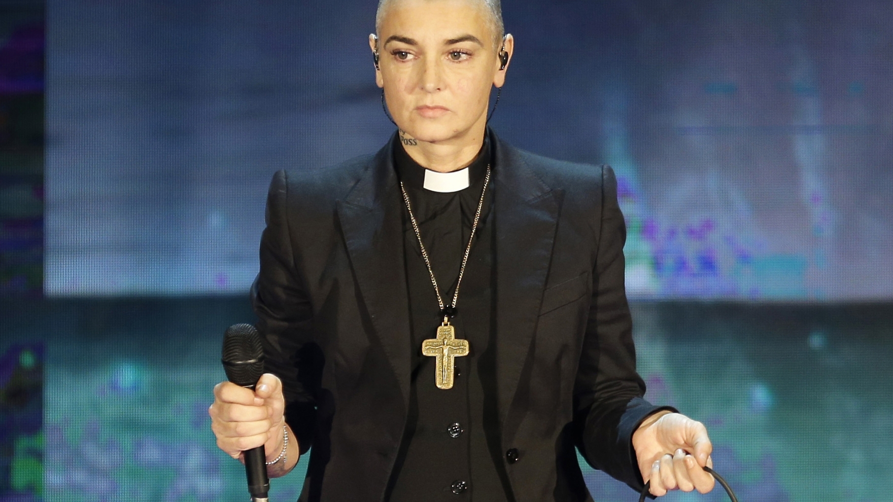 Ajutor, cine altcineva?  |  Fratele lui Sinead O’Connor a fost forțat să facă față preocupărilor legate de o statuie de ceară dispărută la aniversarea morții surorii sale